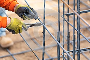 Worker Securing Steel Rebar Framing With Wire Plier Cutter Tool