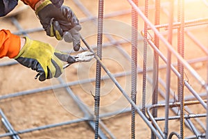 Worker Securing Steel Rebar Framing With Wire Plier Cutter Tool photo