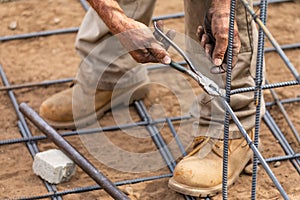 Worker Securing Steel Rebar Framing With Wire Plier Cutter Tool