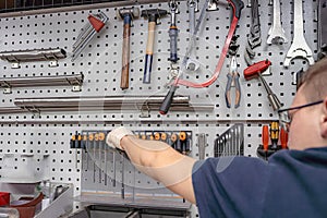 A worker selects a tool for work and repair in a locksmith workshop