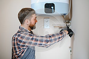 worker set up central gas heating boiler at home