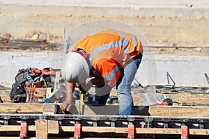 Worker sets guages before cement pour at new Rail Station