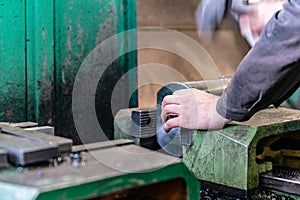 The worker sets the metal workpiece in a vice for processing on a CNC milling machine photo