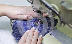 Worker sewing production adjusts the sewing machine