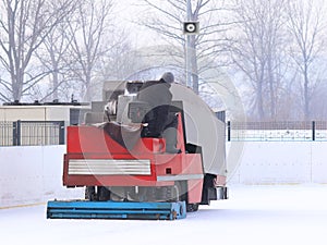 A worker is shooting a special ice maintenant machine at a sports rink. Cooking place for skating. ice preparation at the rink