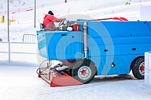 A worker is shooting a special ice maintenant machine at a sports rink. Cooking place for skating. ice preparation at the rink