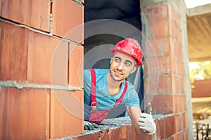 Worker showing ok hand sign on construction site. Building engineer with quality control approving construction