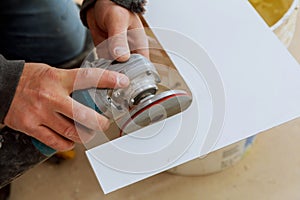 Worker side grinder working on paving tile on building