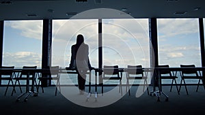 Worker silhouette resting office at sea closeup. Company intern looking window