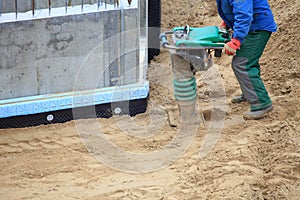 Worker at site working with compress tool