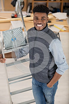 worker smiling holding ladder