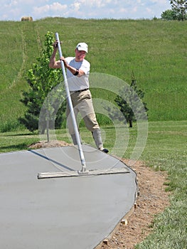 Worker smoothing concrete