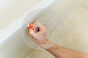 Worker smoothing silicone sealant.