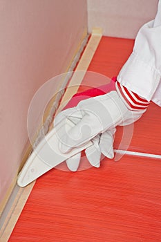 Worker smooths silicone sealant photo