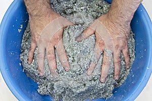Worker soaks and mixes silk plaster.