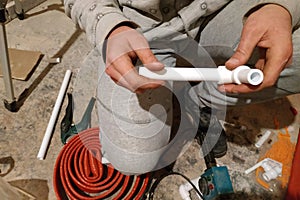 The worker soldered two tubes to heat the floor with a soldering iron