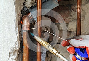 A worker is soldering copper pipes.