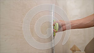 Worker spackles the walls with a spatula. Spatula with putty in hand. Worker puts of plaster on wall.