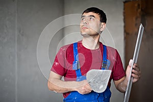 A worker with spatula and level in workwear