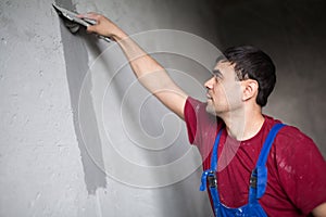 A worker with spatula makes repairs smears on the