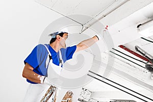 Worker spraying ceiling with spray bottle