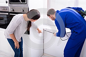 Worker Spraying Insecticide Chemical At Kitchen photo