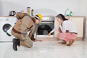 Worker Spraying Insecticides In Front Of Housewife