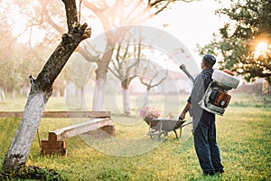 worker spraying organic pesticides for garden treatment