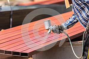 Worker spraying paint to steel pipe to prevent the rust on the surface photo