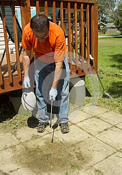 Worker Spraying Weed Killer On A Old Patio