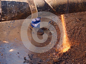 Worker staff cut big metal tube with grinder. Burning red parks