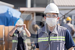 The worker staff, engineer protects himself from covid-19 coronavirus with a protective mask in the construction site.