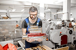 Worker with stamping foil rolls at the manufacturing