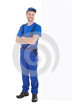 Worker standing arms crossed while leaning over white background