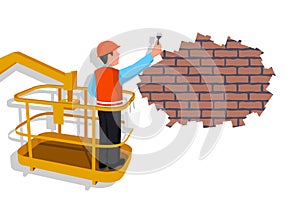 Worker standing in an assembly cradle paints a wall representing