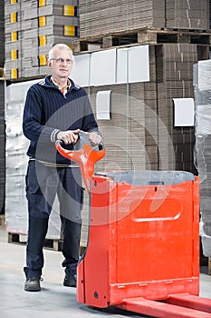 Worker Standing With Handtruck At Warehouse photo