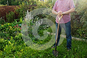 Worker standing with shovel in the garden, ready to loosen ground