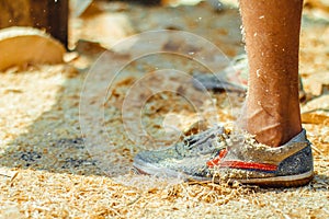 The worker stands in the sawdust