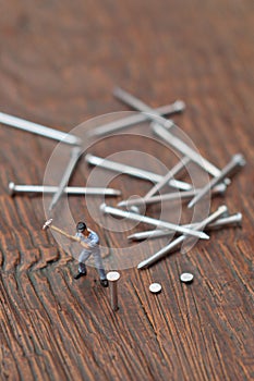Worker sticks nail. Hard work concept