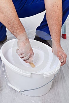 Worker stirring the paint - closeup on hands