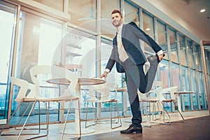 Worker stretching leg at table in office.