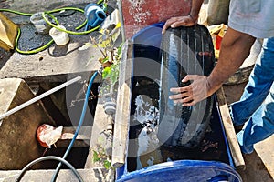 Worker submerge tyre into water container for bubble to check point of punctured