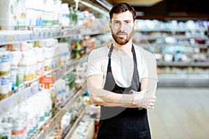 Worker in the supermarket with dairy products