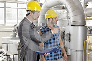 Worker with supervisor inspecting industrial area