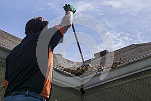 Worker Sweeping Leaves From Roof Valley