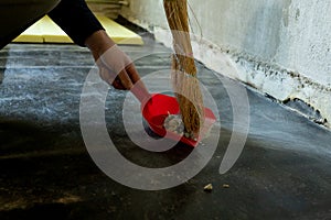 Worker sweeps construction debris with a broom.