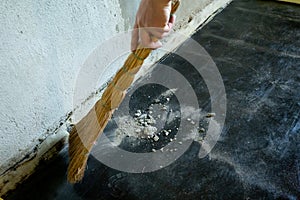 Worker sweeps construction debris with a broom.