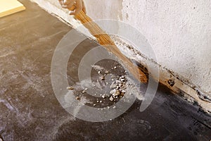 Worker sweeps construction debris with a broom.