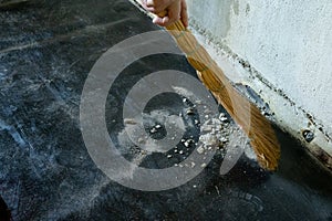 Worker sweeps construction debris with a broom.