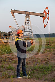 A worker with a tablet monitors the serviceability of oil pumps